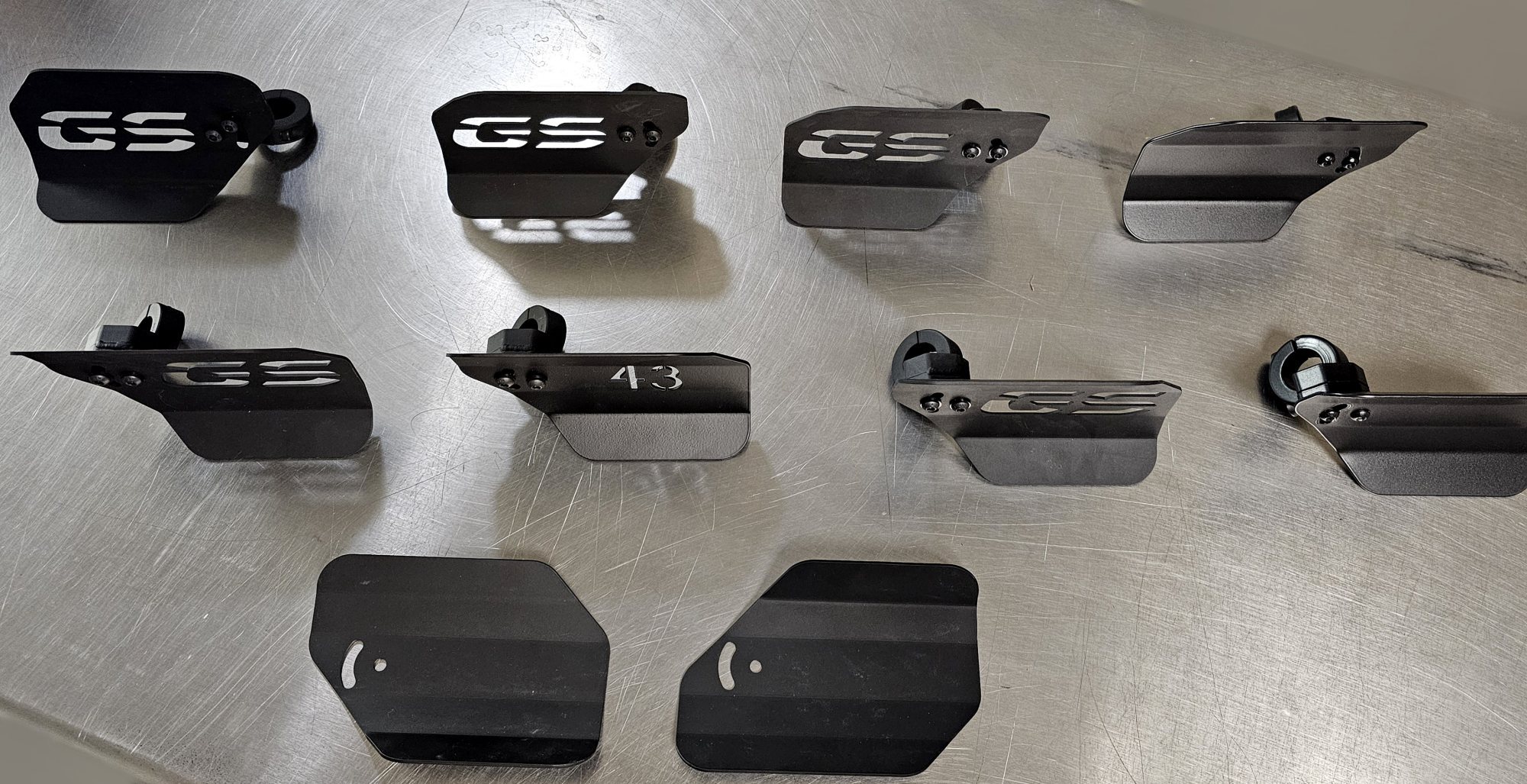 Ten Calf Rests laid out on a steel bench showing plain, numbered and cutout designs