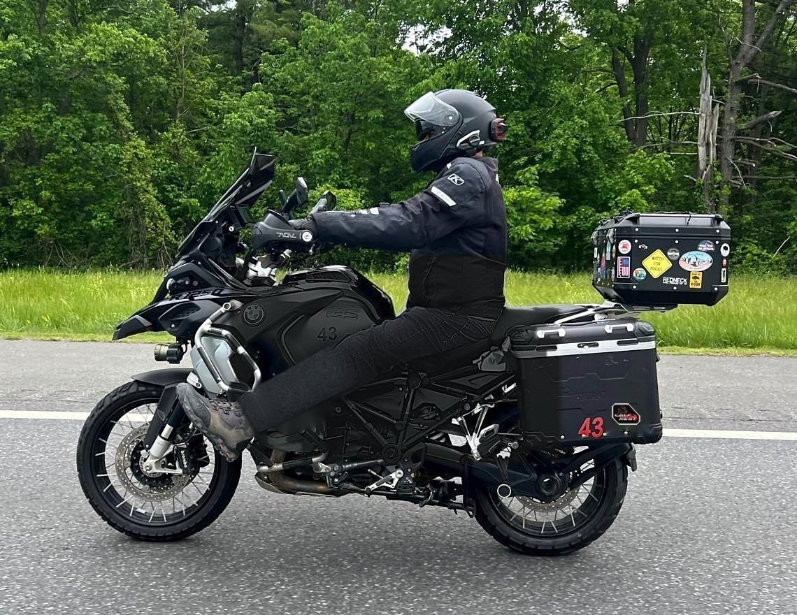 Black R1250 GSA cruising with rider's legs stretched out